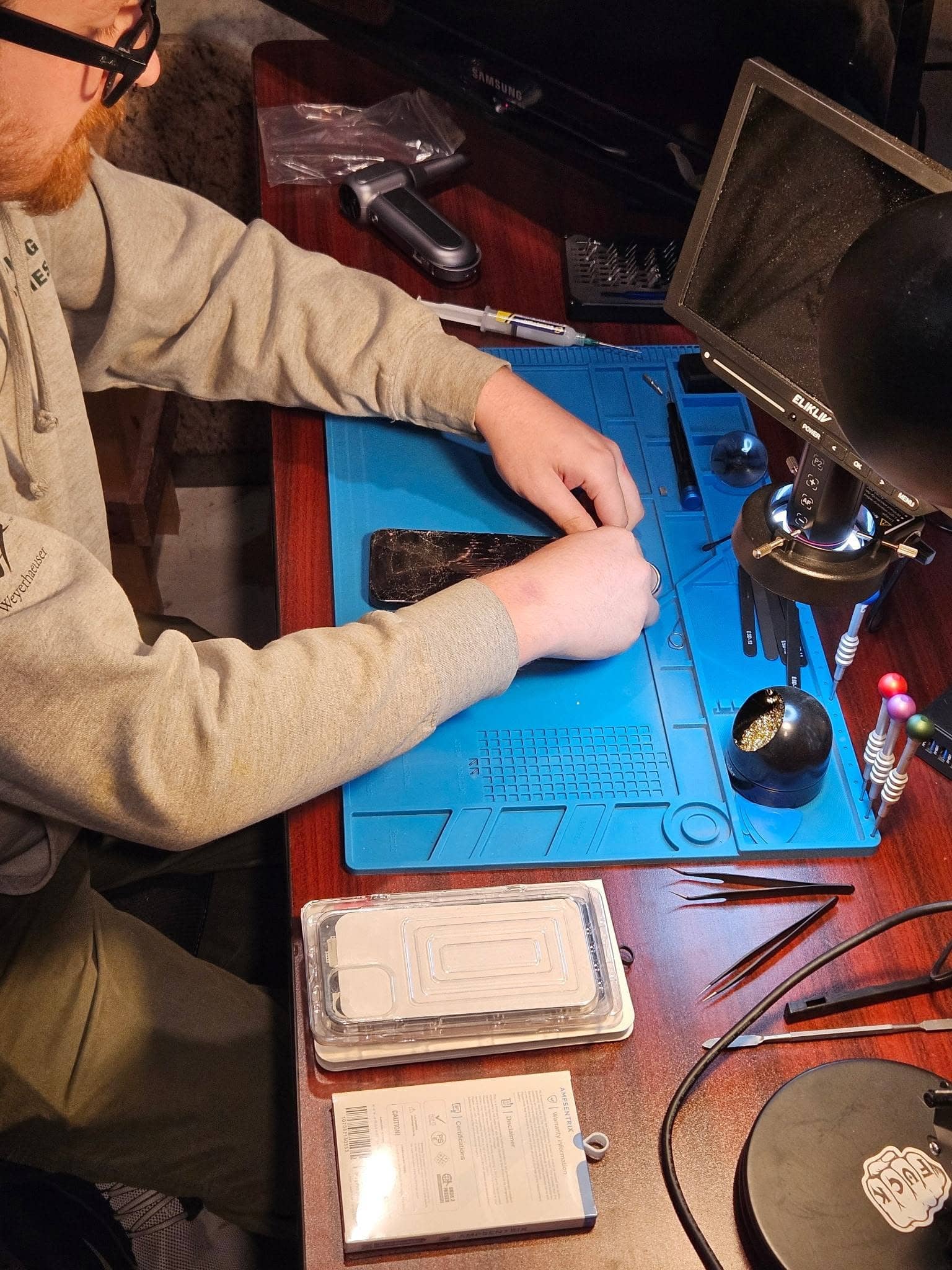 Technician working on a phone at the MPR workbench